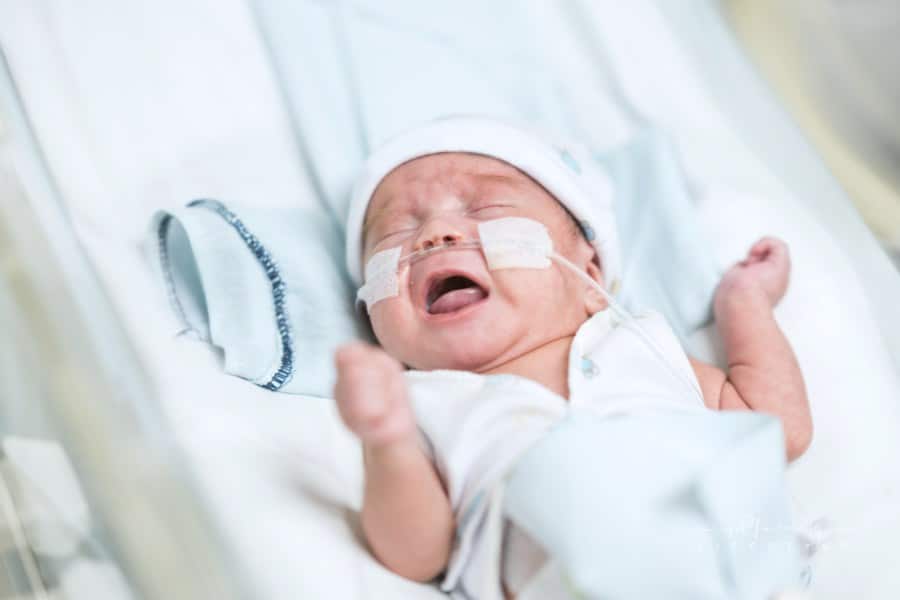 Beautiful baby boy in neonatal intensive care unit with oxygen crying