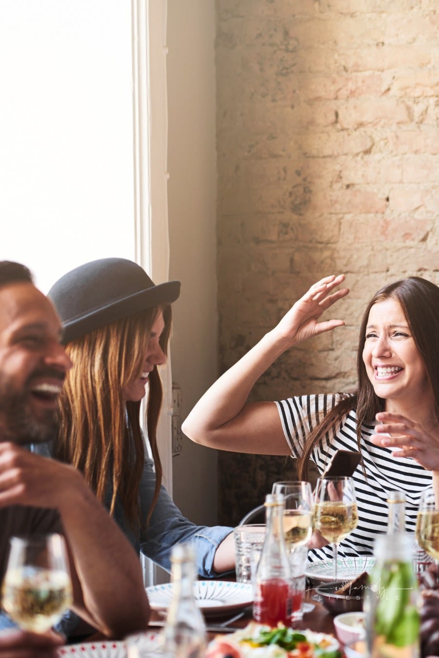 Laughing Friends Having Wine and a Meal Together