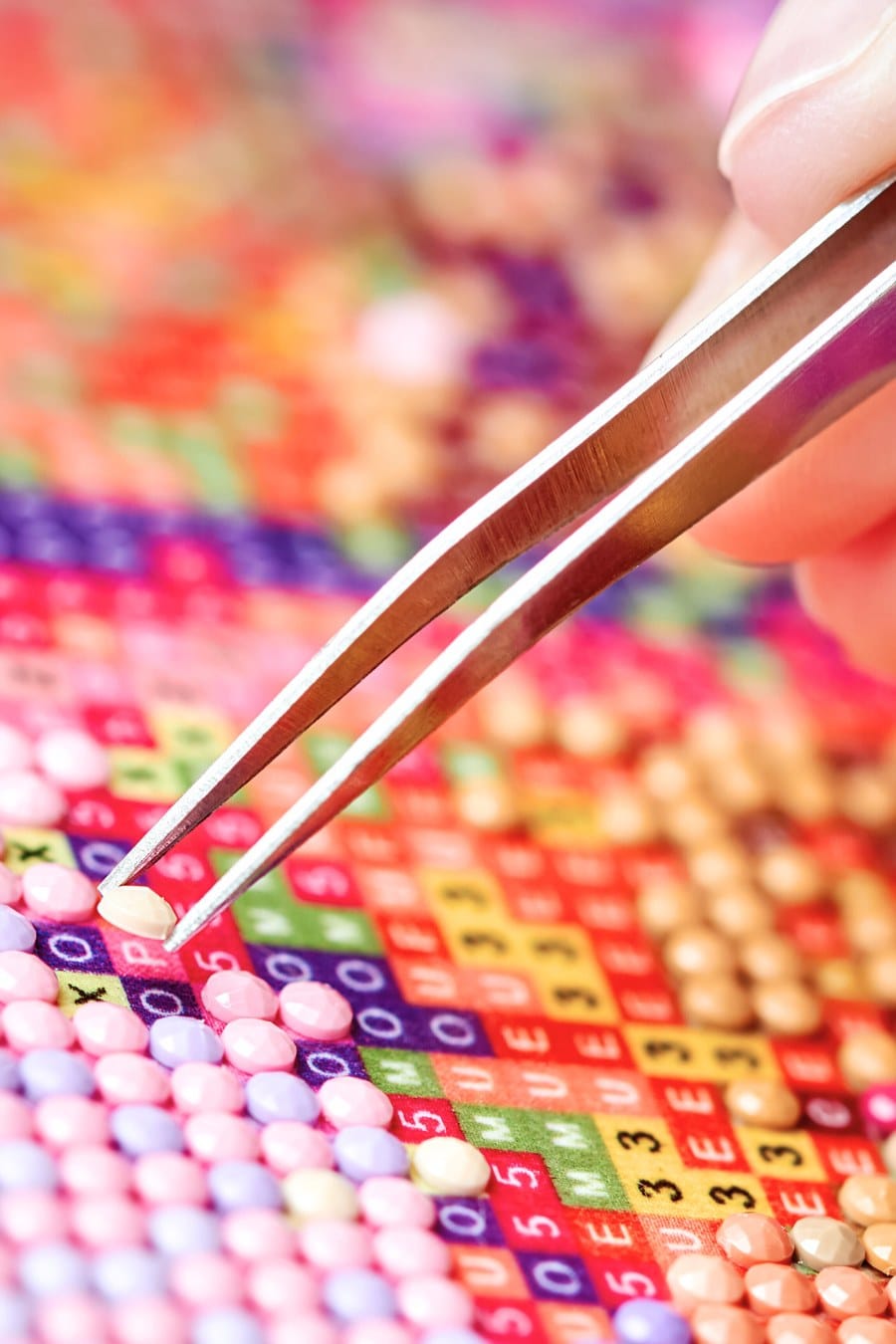 Girl Collect Diamond Painting. Diamond Embroidery with a Tweezers. Acrylic Rhinestones. Close-up, Selective Focus.