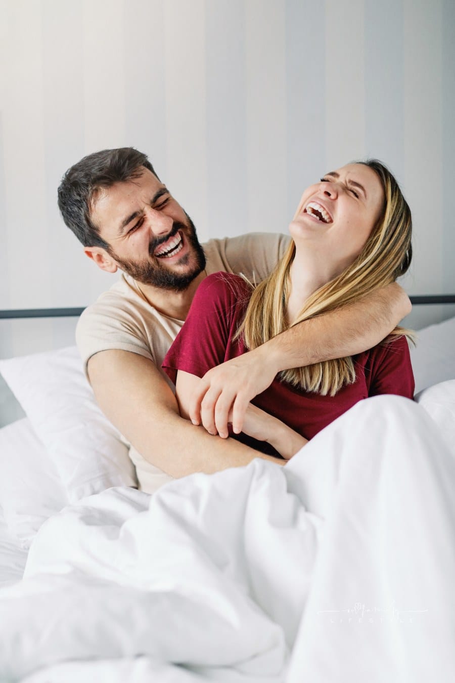 Portrait of a young couple laughing together at home