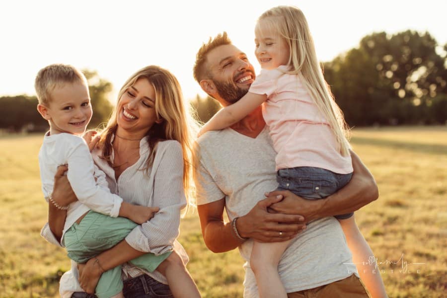 Mother and father enjoying beautiful summer day outdoors with kids