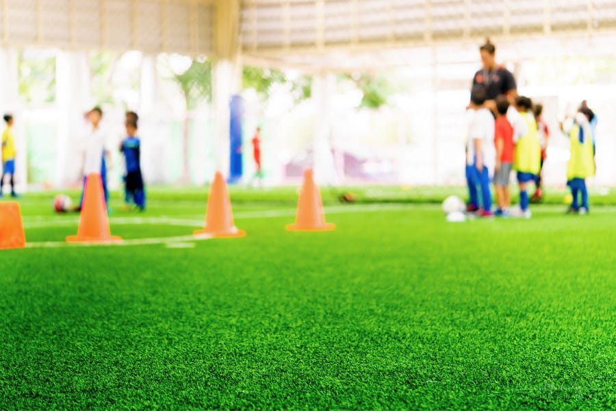 children playing field day games on painted field with cones