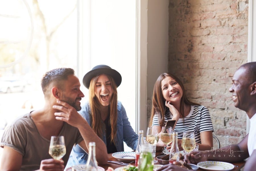 Laughing Friends Having Wine and a Meal Together
