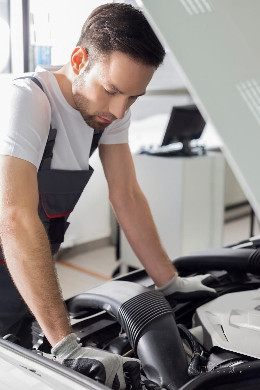 mechanic checking under car hood
