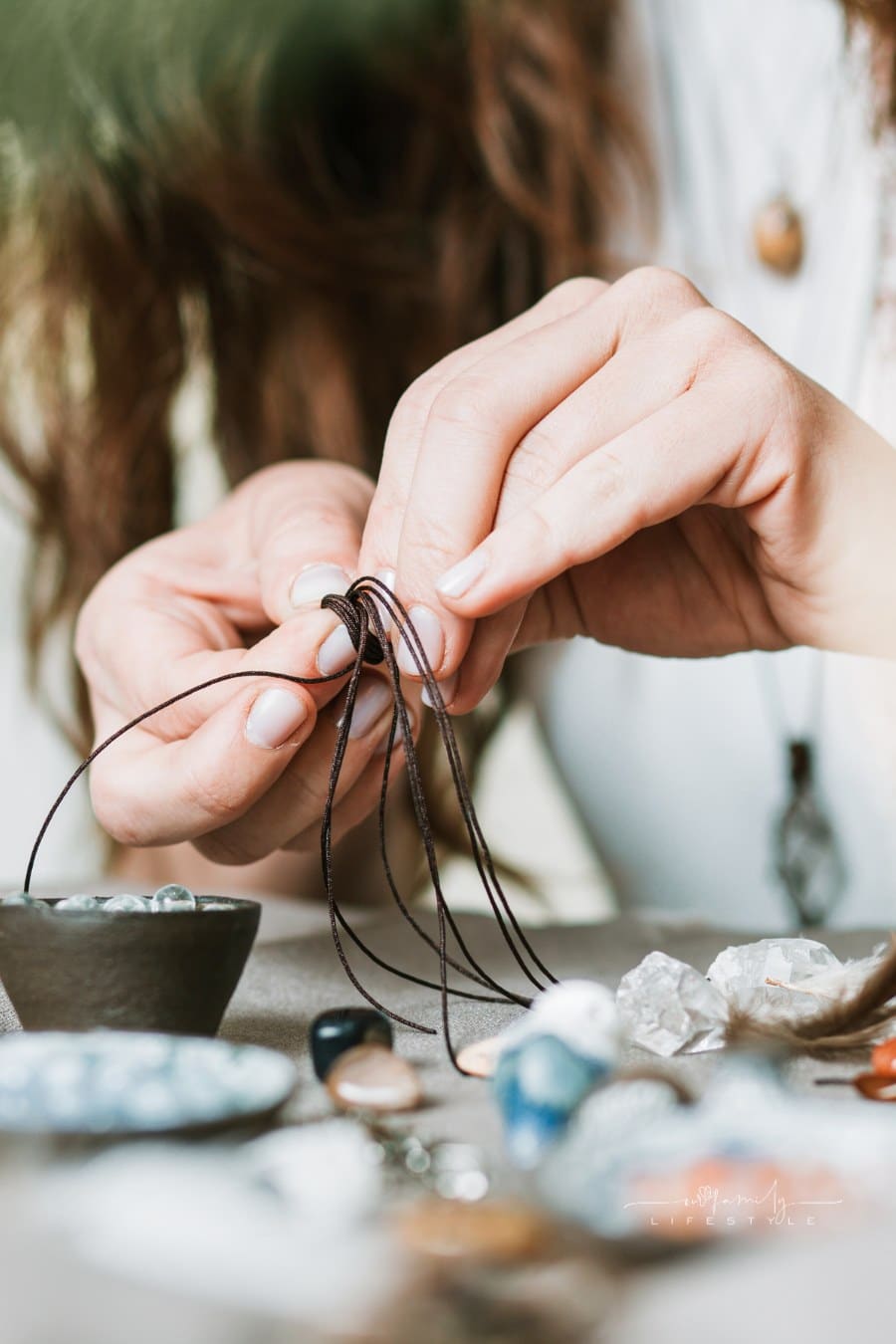 Woman hands making handmade gemstone jewelry, home workshop. Woman artisan creates jewelry. Art, hobby, handcraft concept