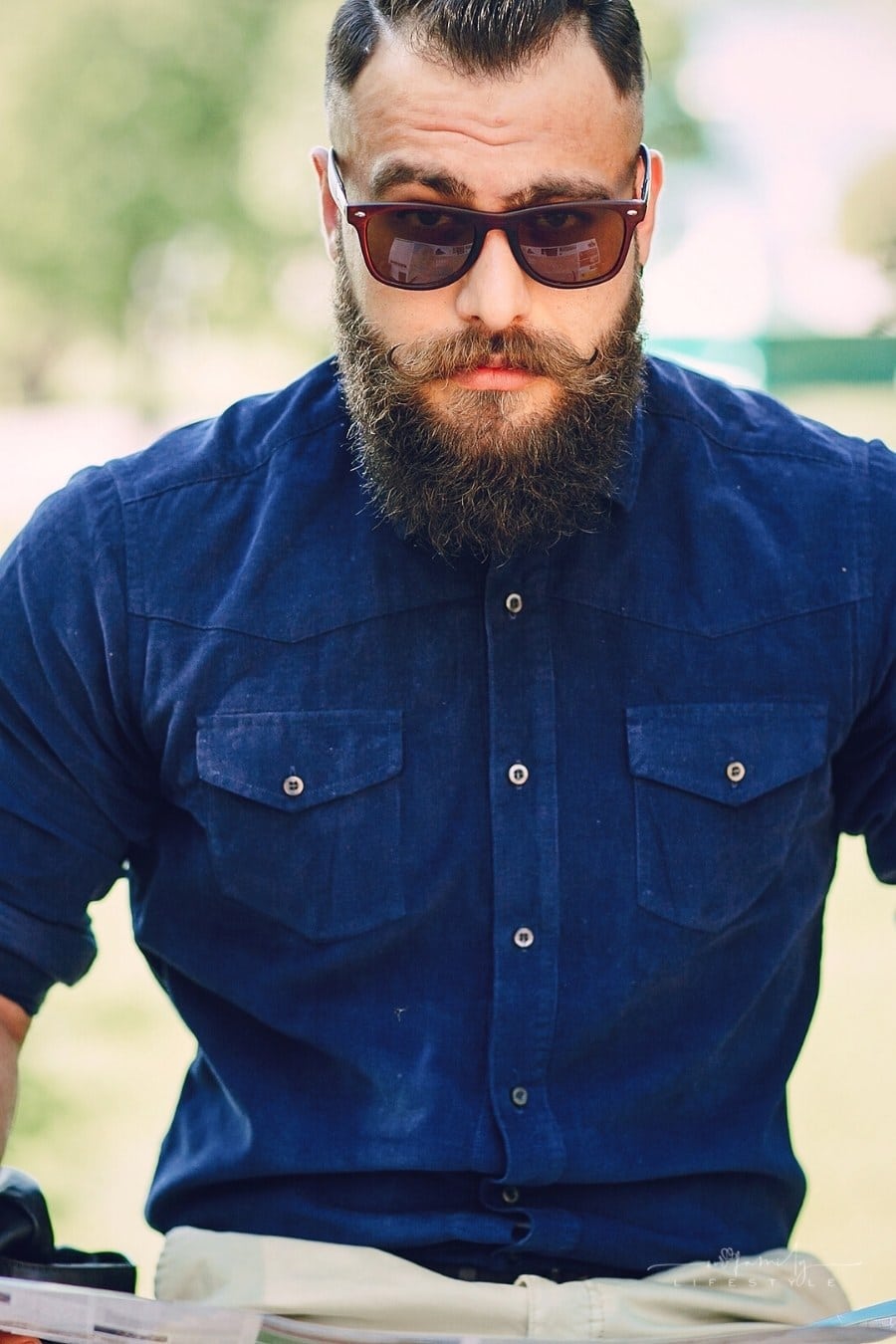 bearded man with sunglasses looking into camera