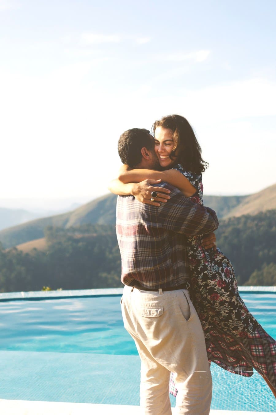 Couple embracing and looking at each other near a swimming pool
