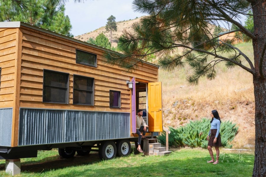 Young couple outside their tiny house