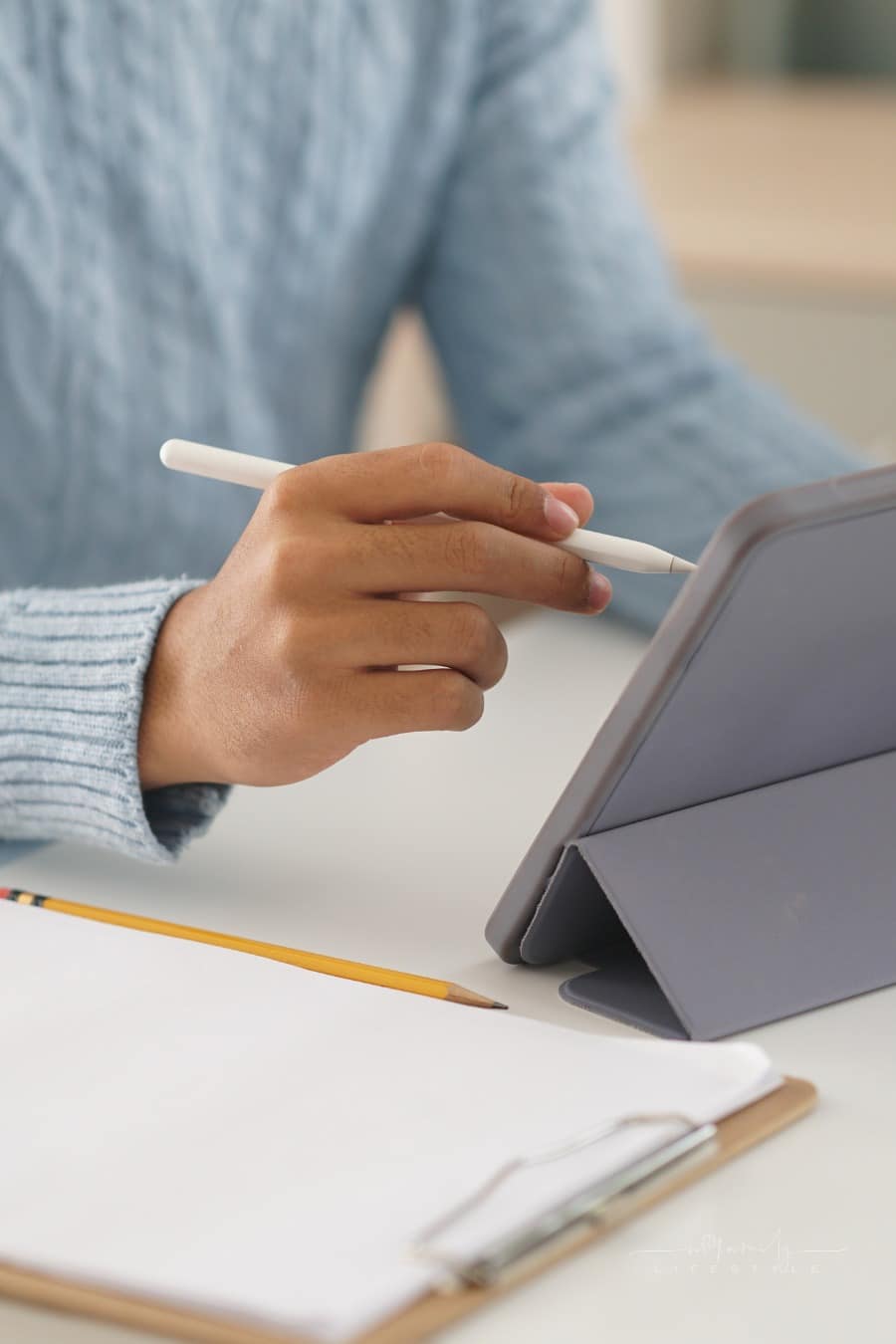 male student doing homework onm digital tablet