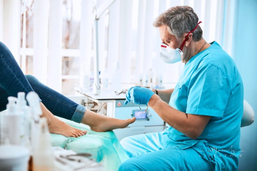 side view of podiatrist wearing gloves while removing pain in toes of a female foot