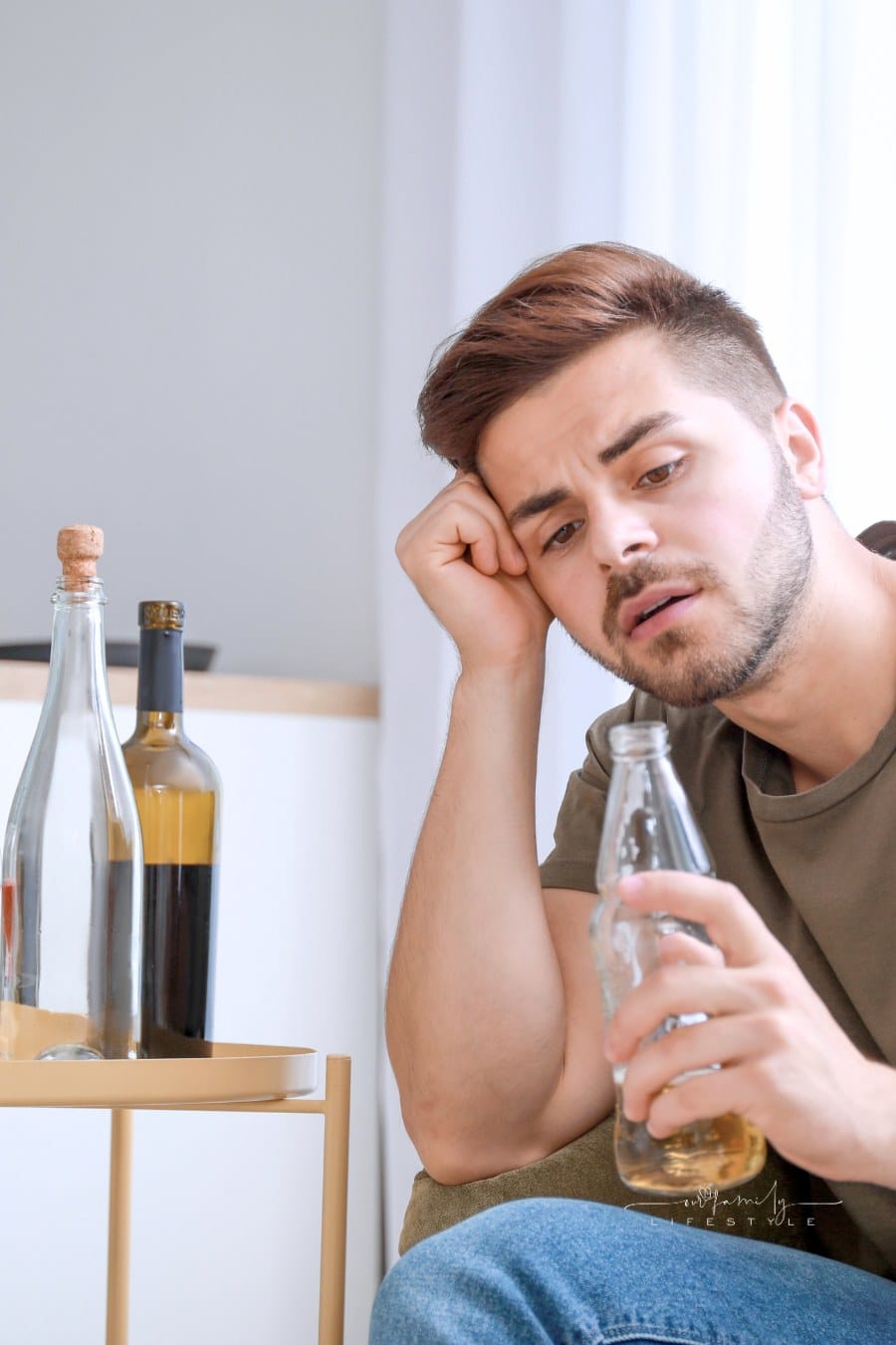 Young Man with Addiction to Alcohol Drinking Beer at Home