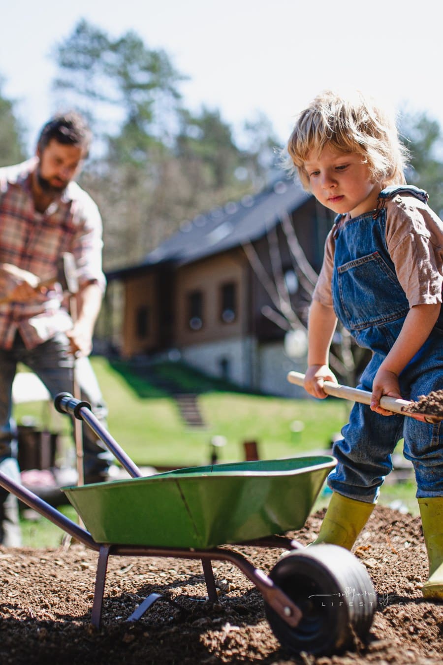Father with Small Son Working in the Garden Outdoors