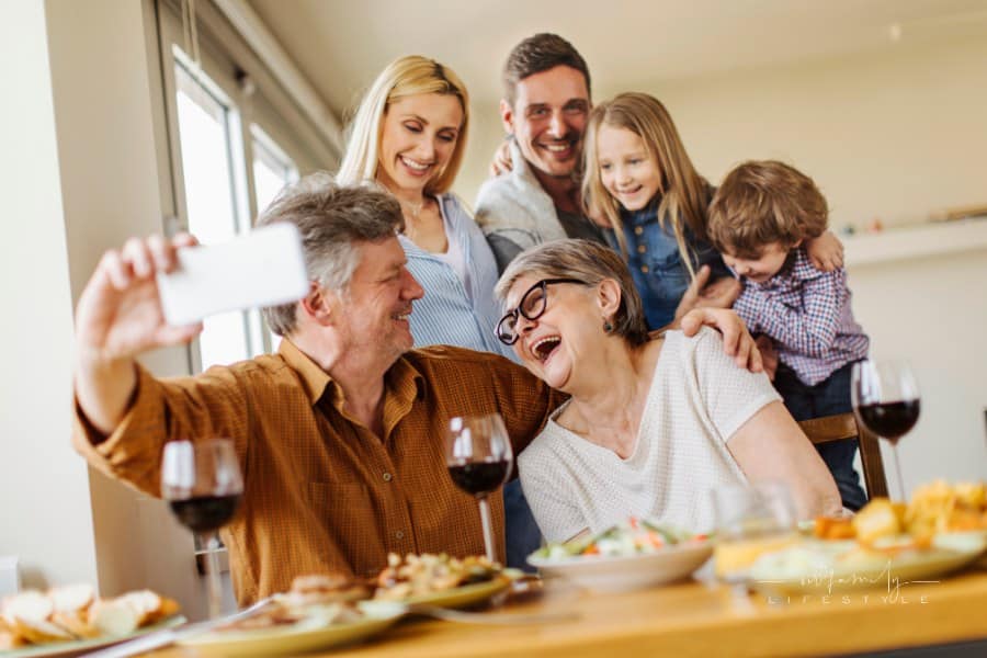 Multi-generation family gathering at table for a picture together