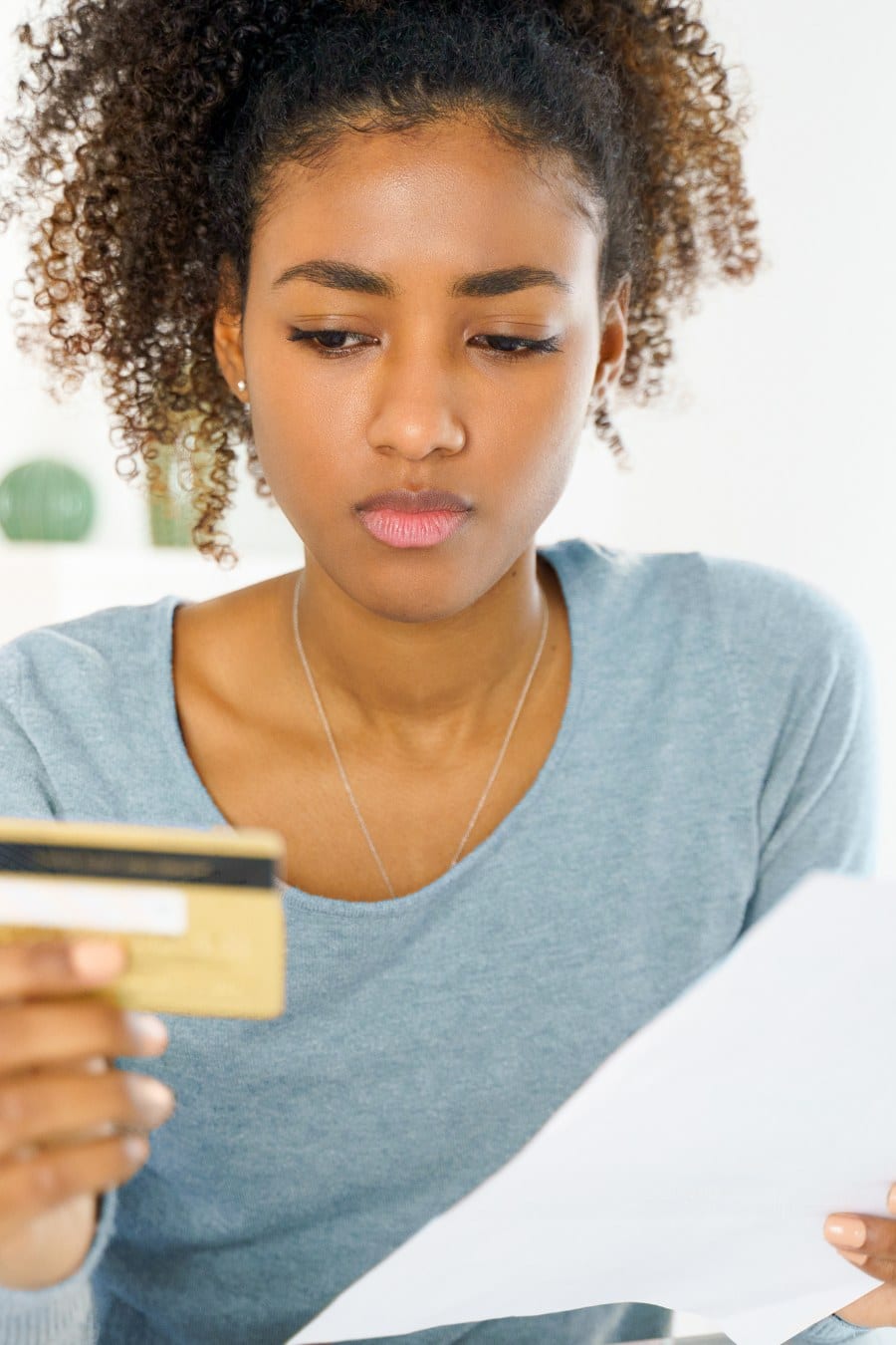 Frustrated young woman reading credit card statement