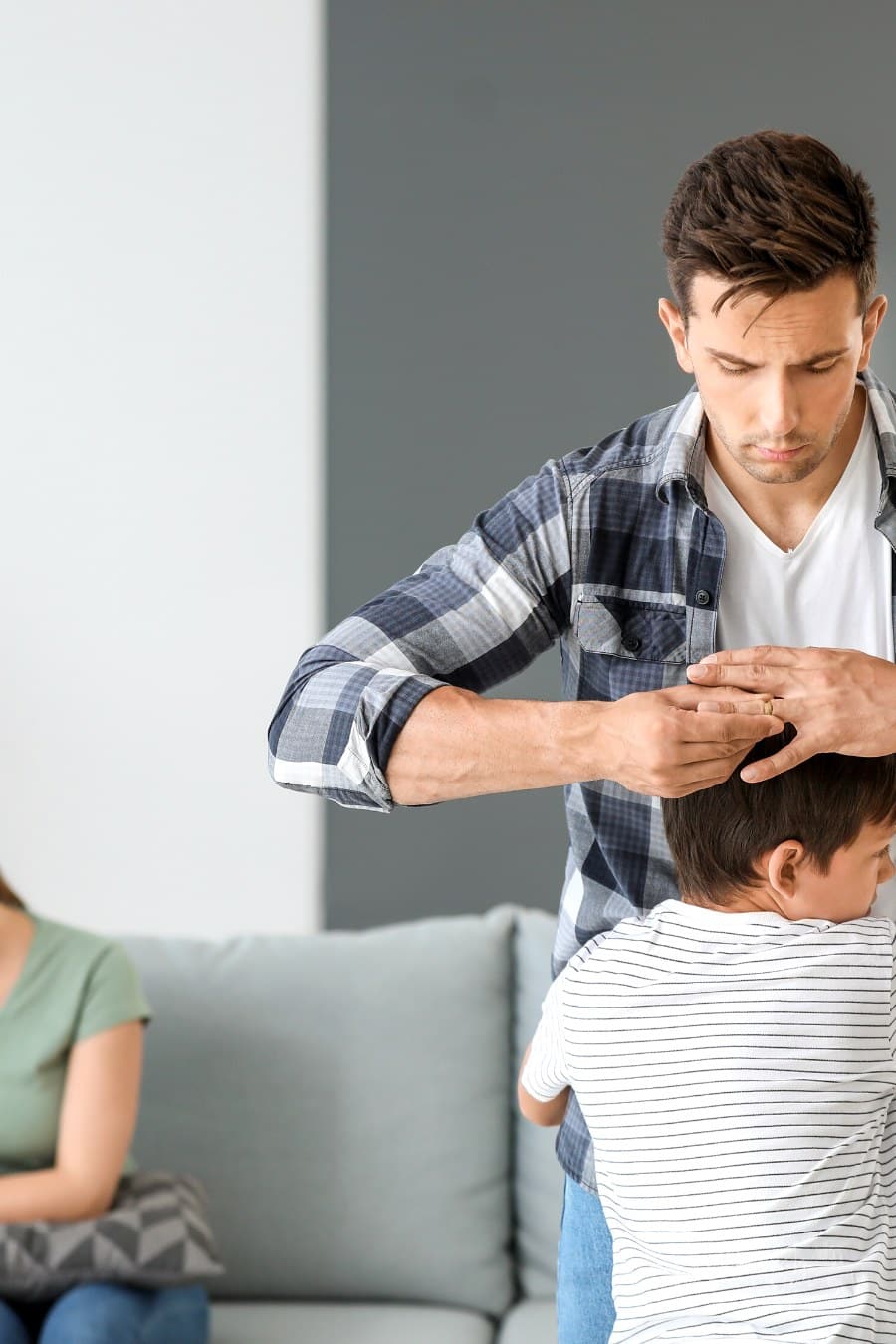 young son hugging father as the dad pulls wedding ring off his finger divorce concept