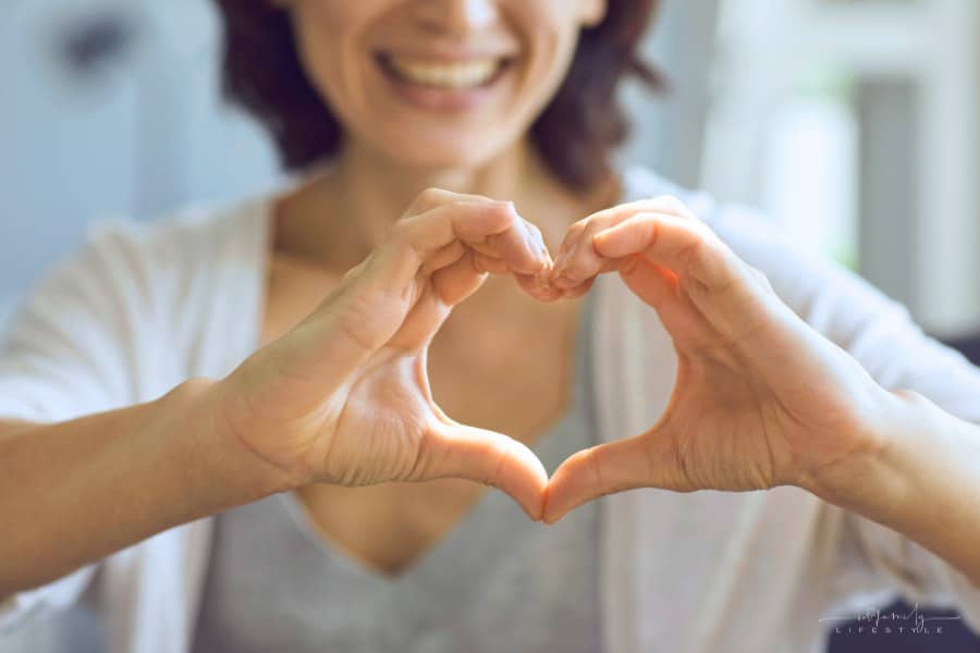 woman showing gratitude with a smile and hands shaped as a heart