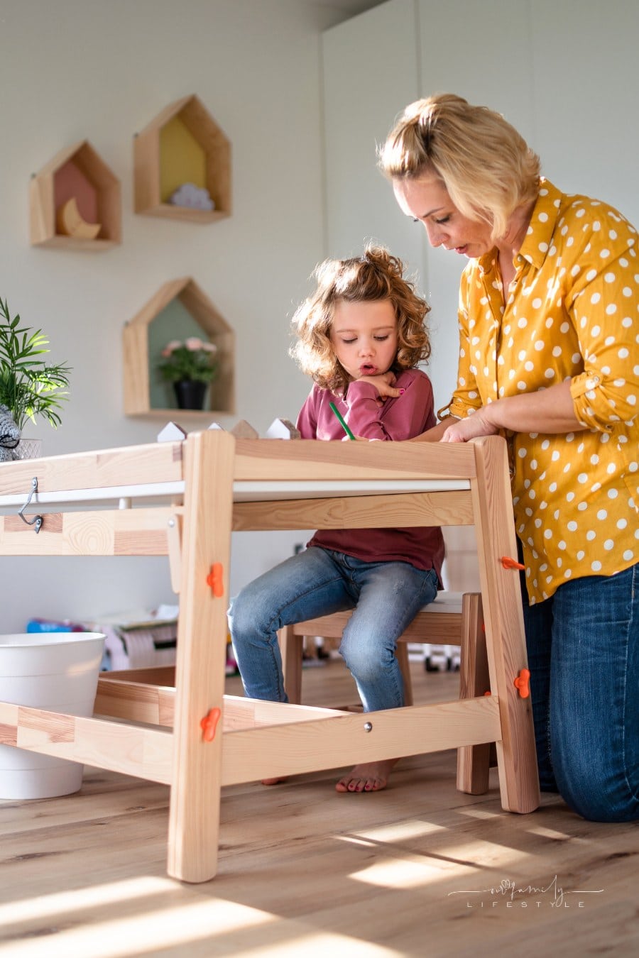 A cute small girl with mother in bedroom indoors at home, drawing pictures.