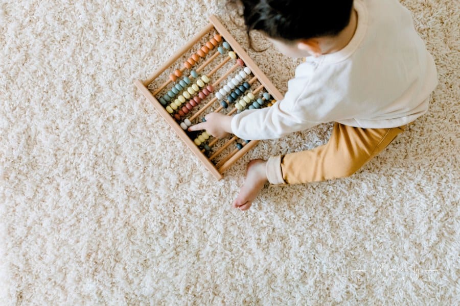 Top View of a Child Playing with an Educational Toy on carpet