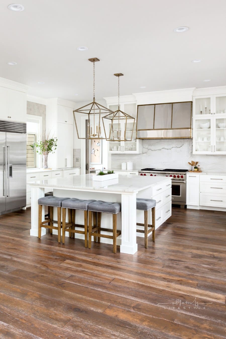 beautiful kitchen in new luxury home with island, pendant lights, and hardwood floors