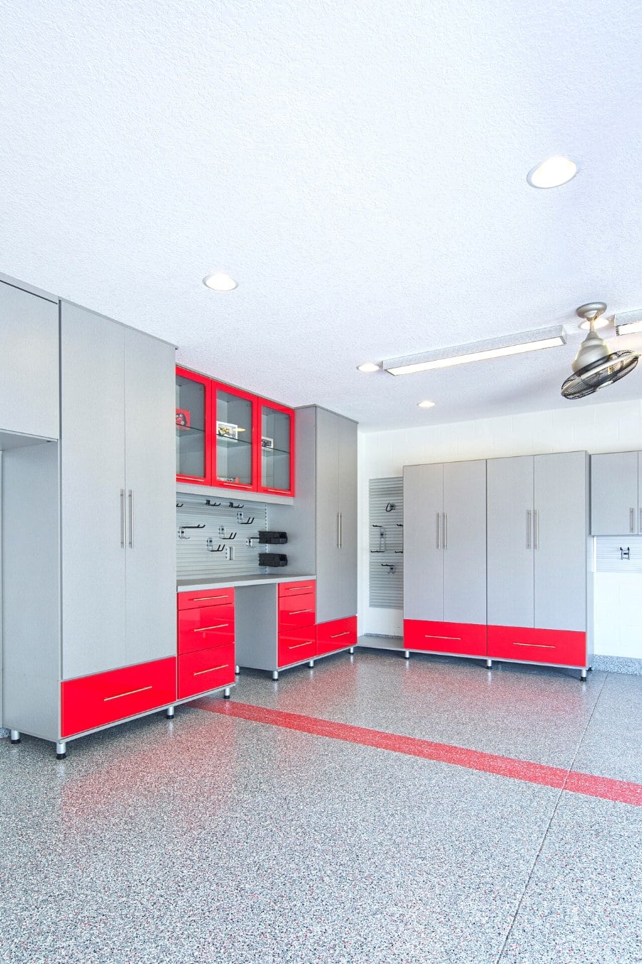 bold colored storage cabinets, organization tracks, and flooring in garage space