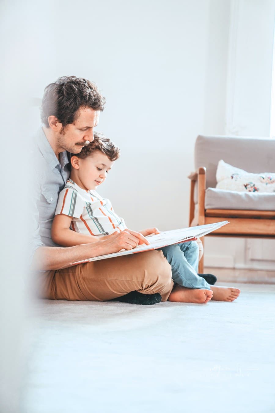 father reading a book with his young son
