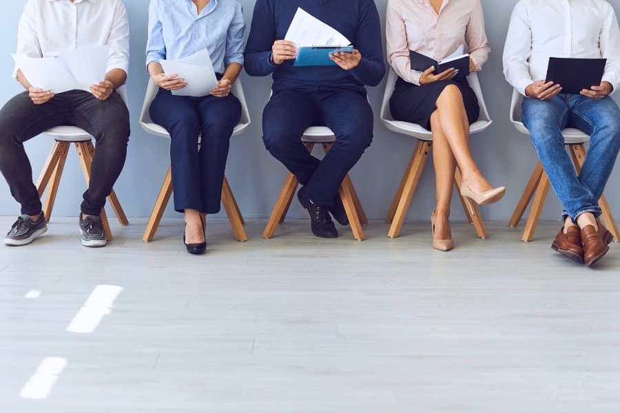 job seekers sitting in a row of chairs awaiting interview