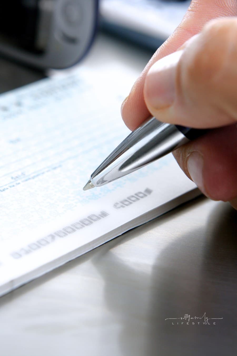Man's Hand Holding A Pen While Signing a Check