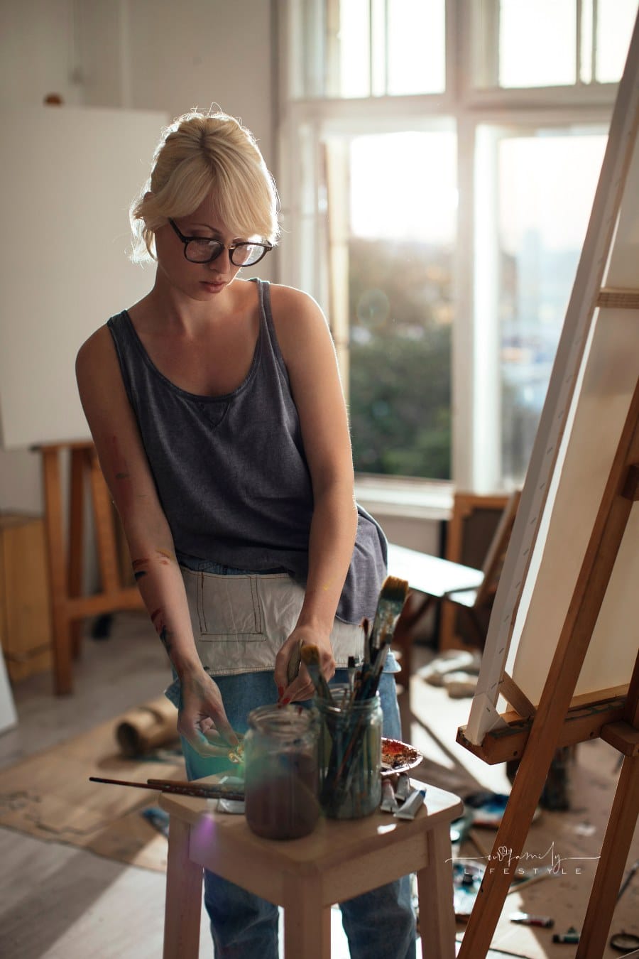 artist painting in a light-filled art studio