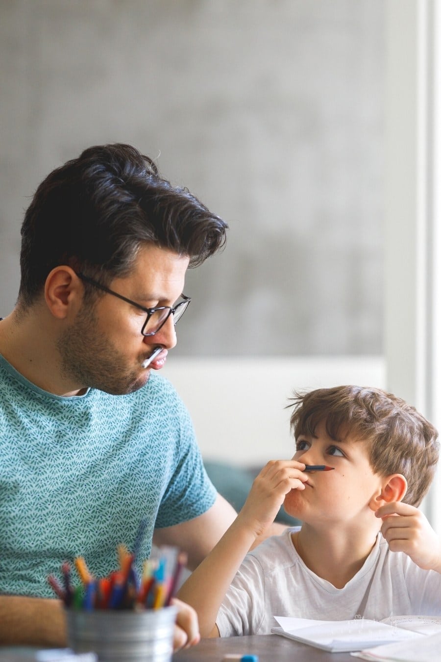 father homeschooling his son in a playful way