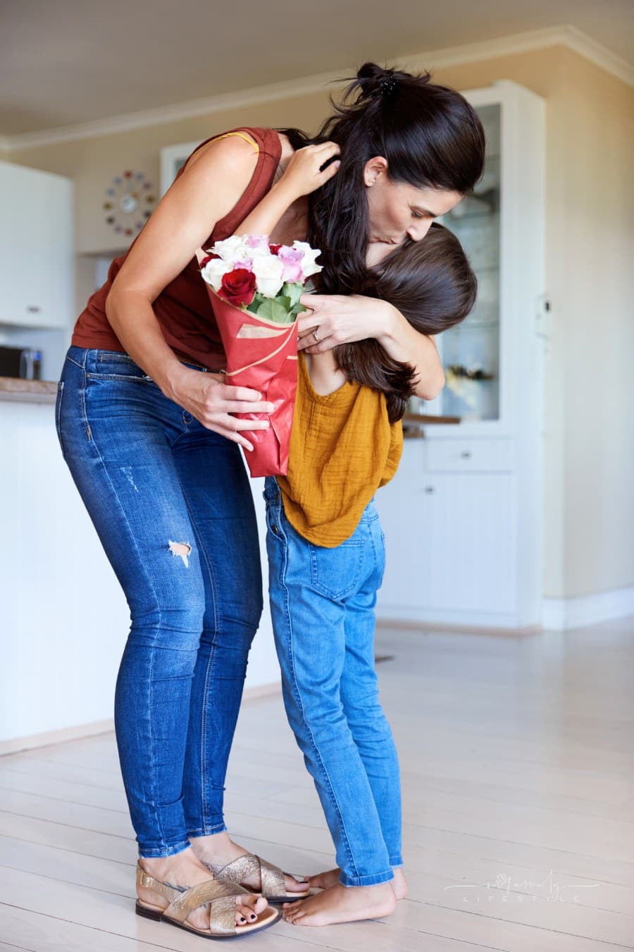 mom hugging daughter to thank her for flowers
