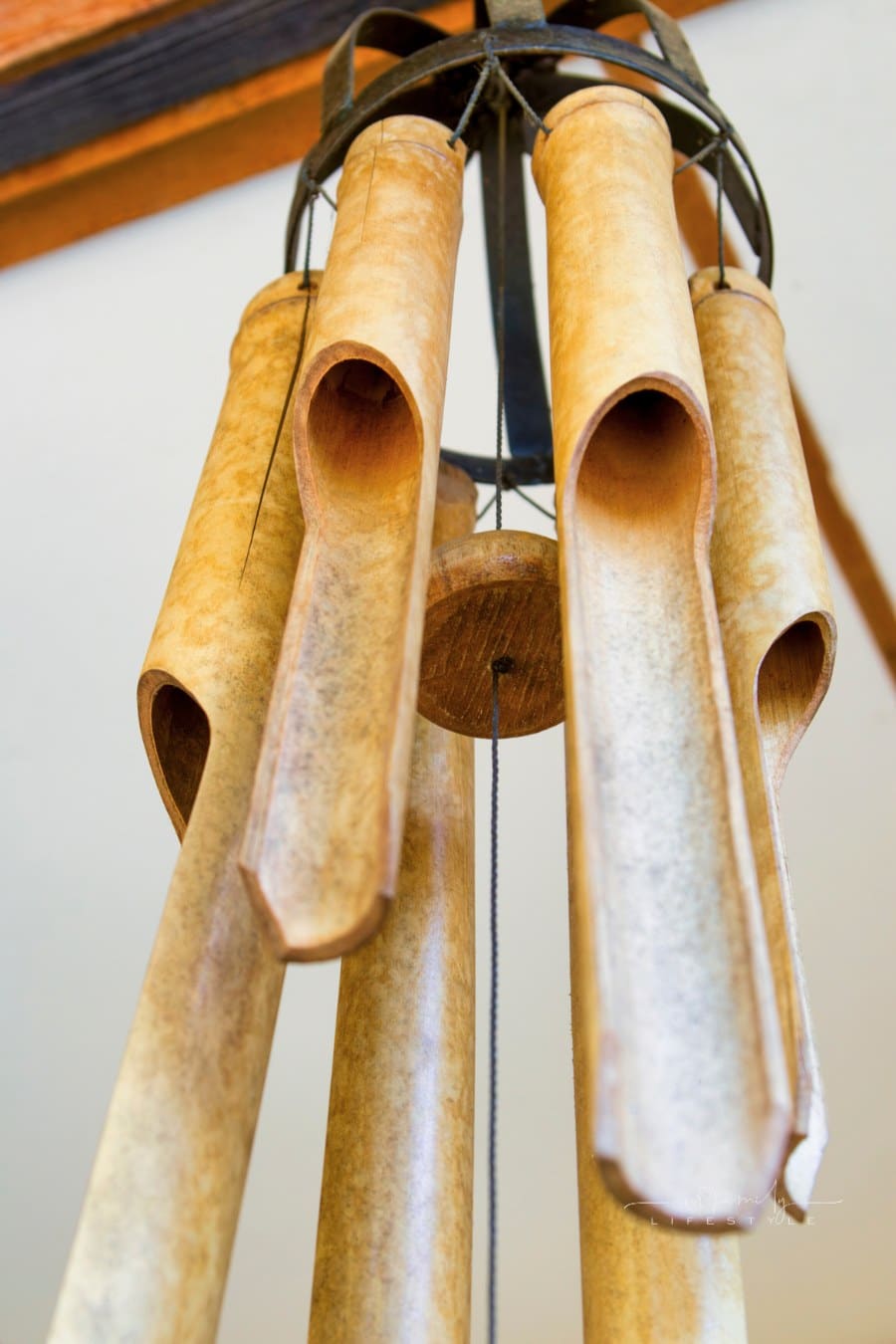 bamboo wind chime hanging on an exterior house wall