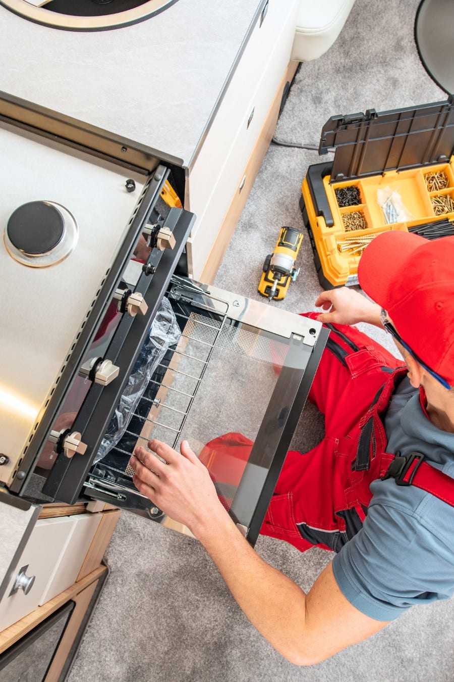 RV Technician Replacing Broken Travel Trailer Gas Stove