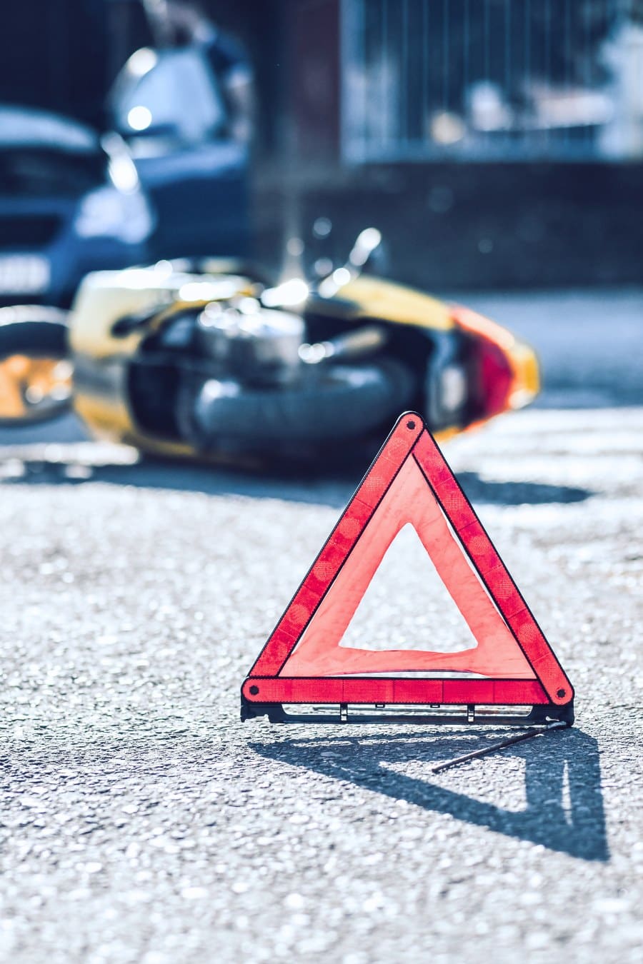 red Warning Triangle in front of motorcycle accident scene
