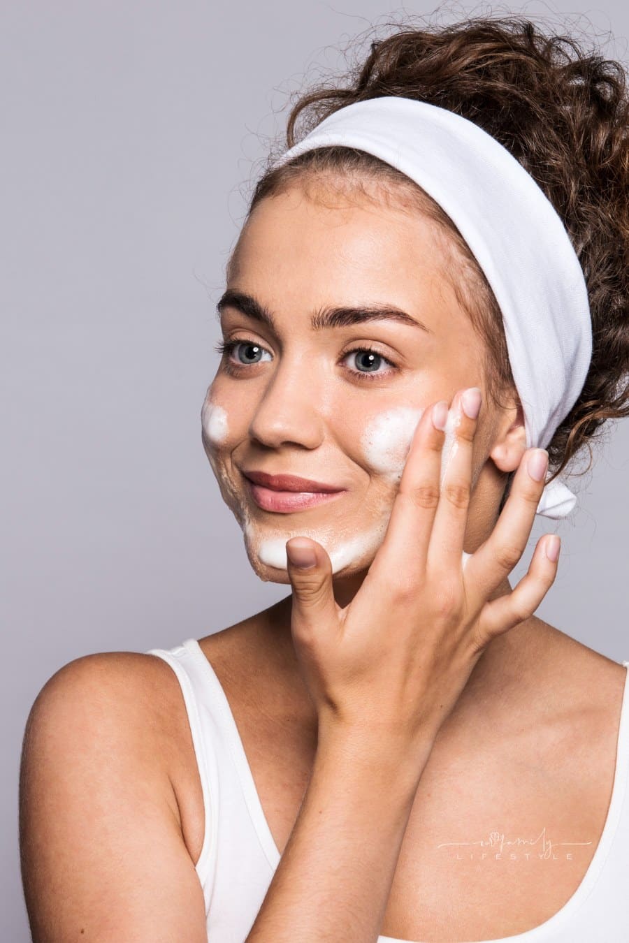 Portrait of a Young Woman Cleaning Face in a Studio, Beauty and Skin Care.
