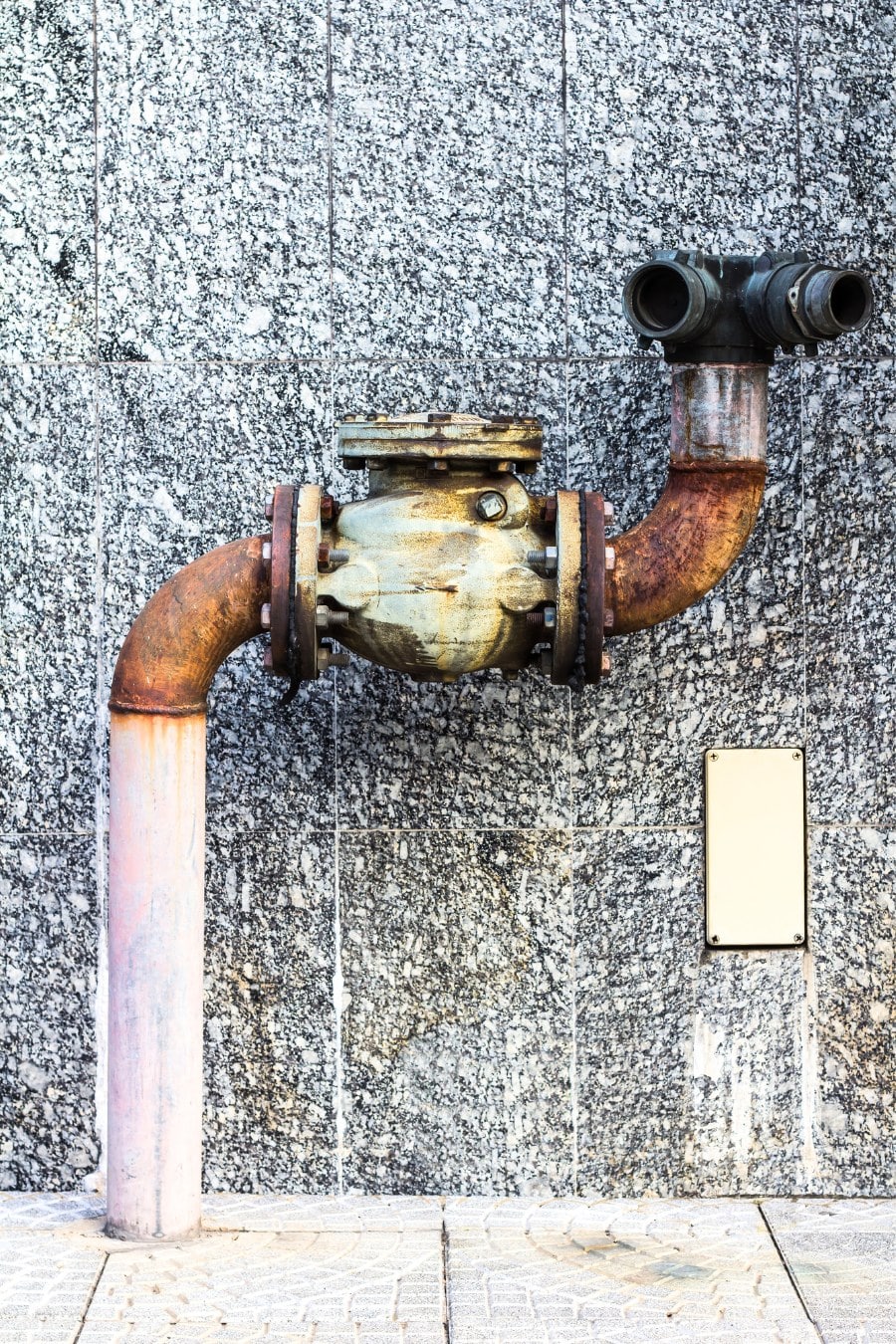 old plumbing fixture on a marble wall