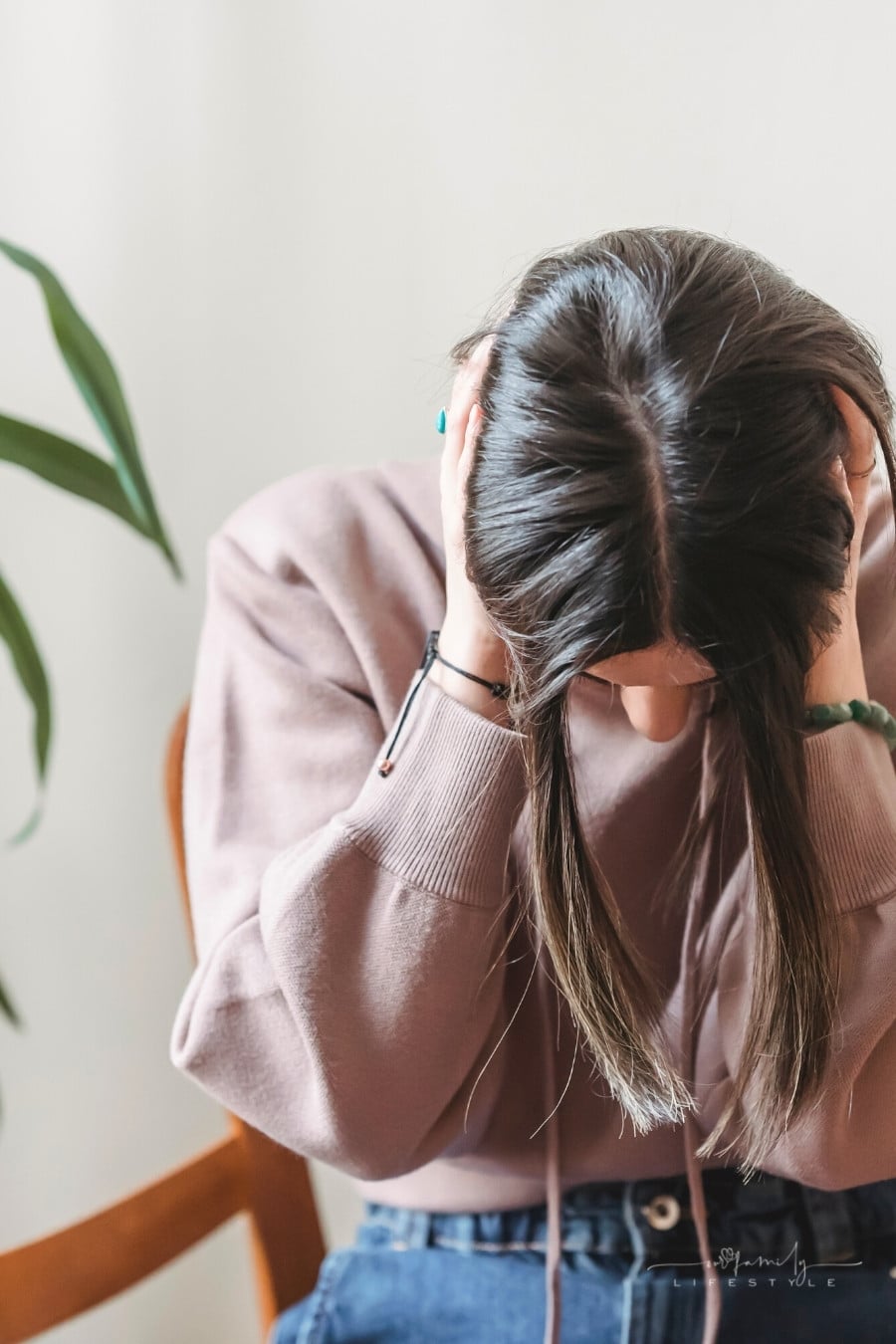 stressed young woman holding head in hands