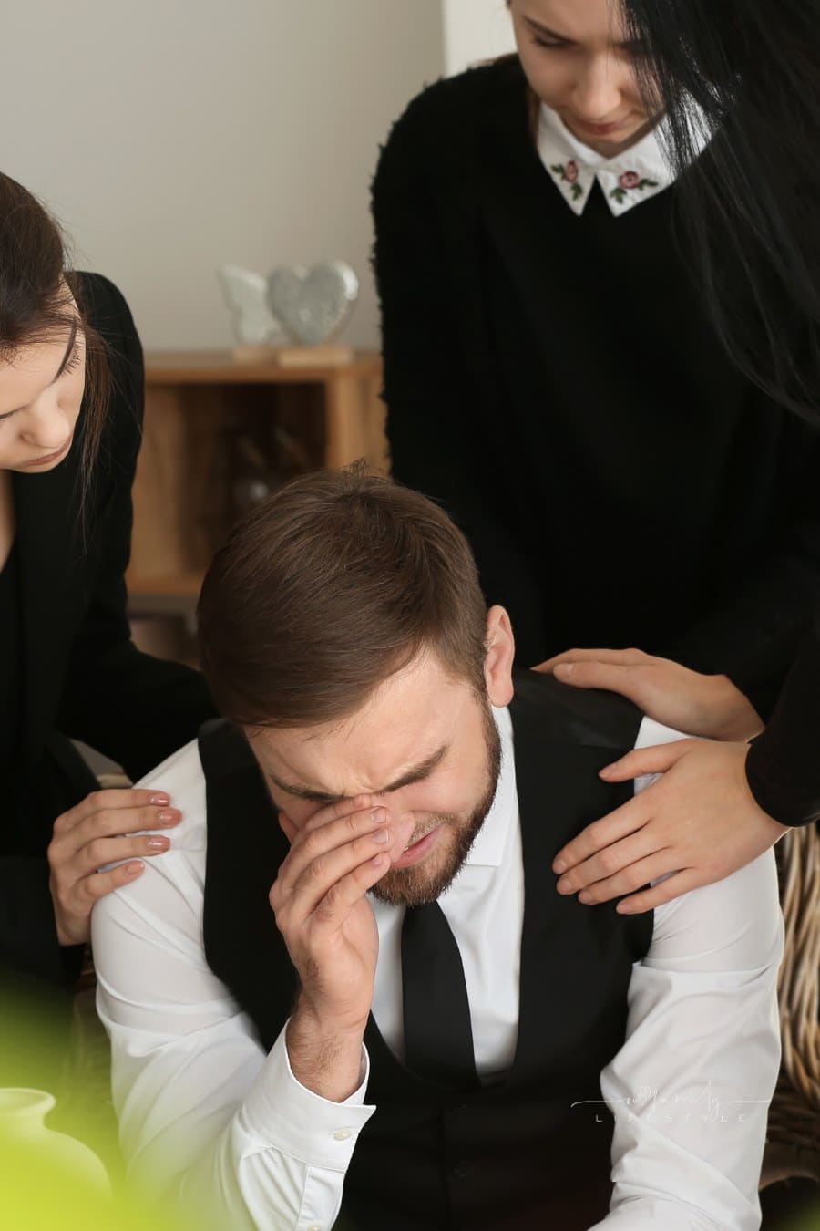 Relatives Calming Young Widower at Funeral