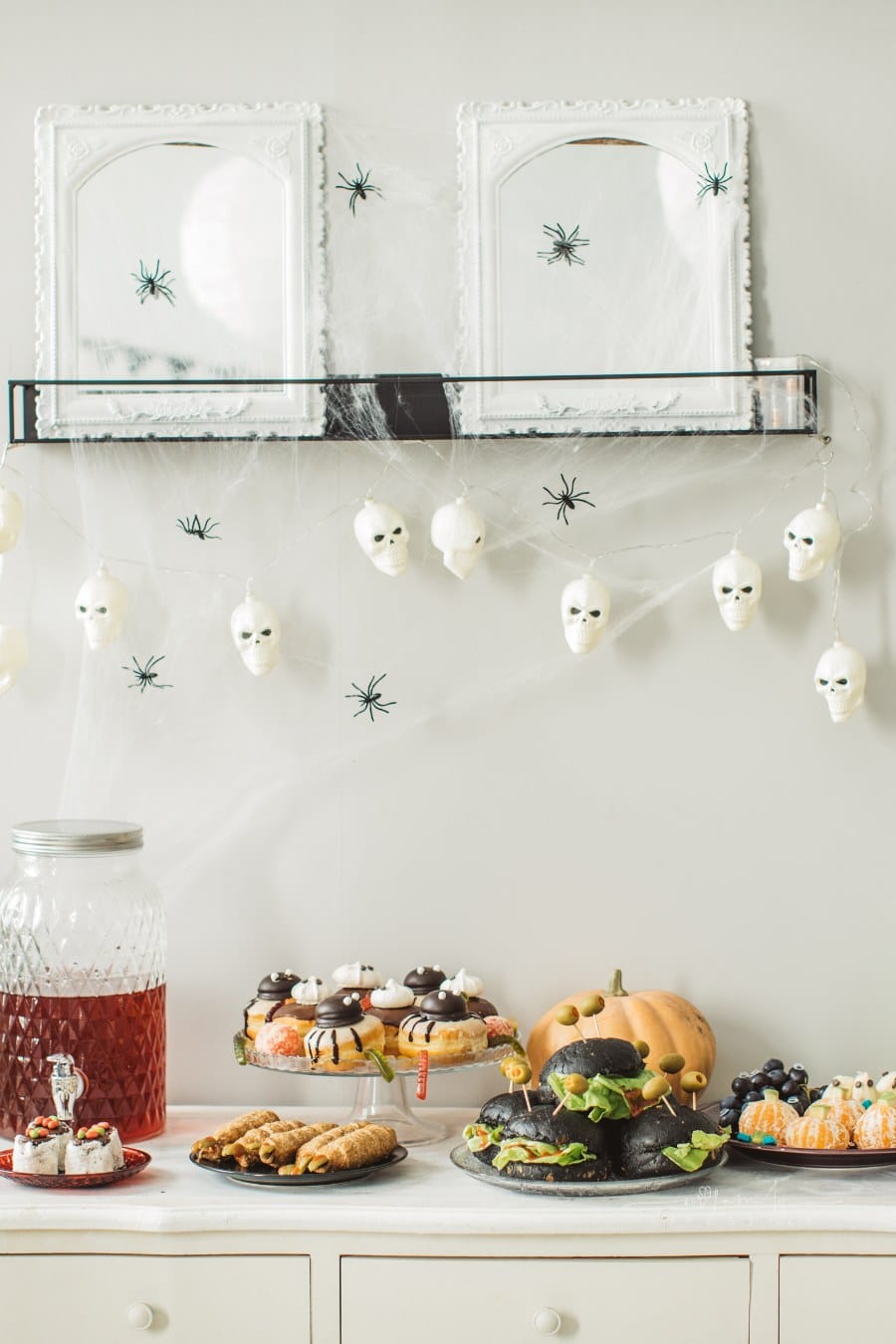 Food table filled with different type of food and drinks ready for Halloween party