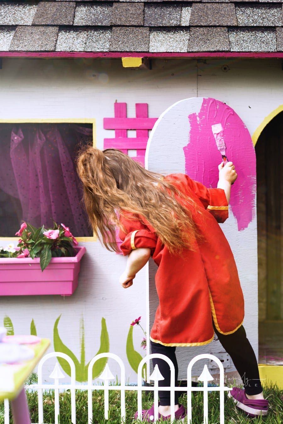 Little girls painting her playhouse