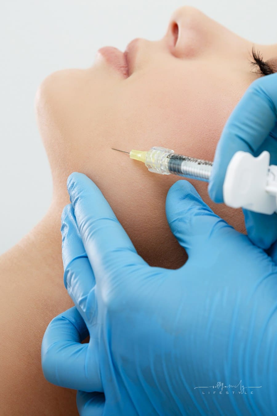 Syringe with filler for face contouring or augmentation. Model with closed eyes, profile, close-up. Healthcare, cosmetology, clinic