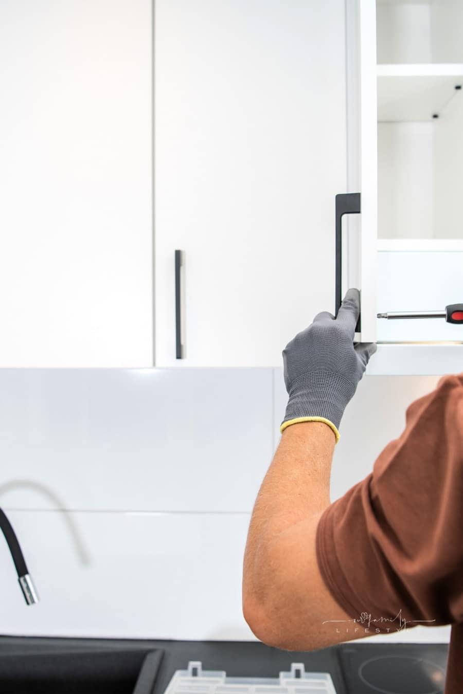 man adding handles to kicthen cabinet