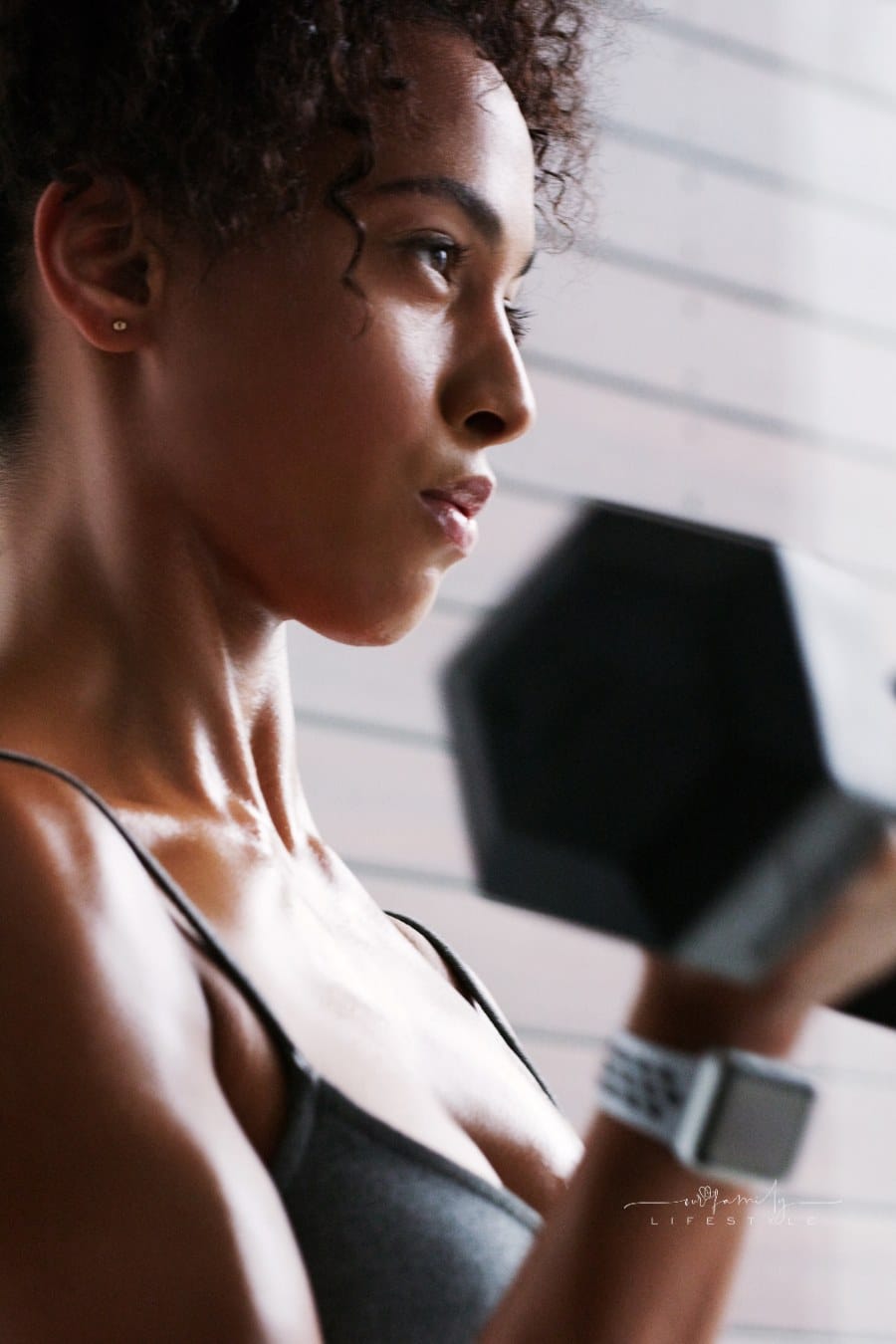Shot of a young woman working out with dumbbells in a gym
