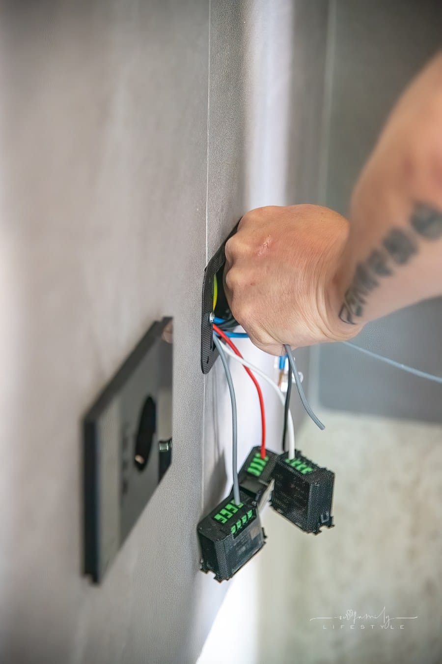 electrician installing outlet on wall
