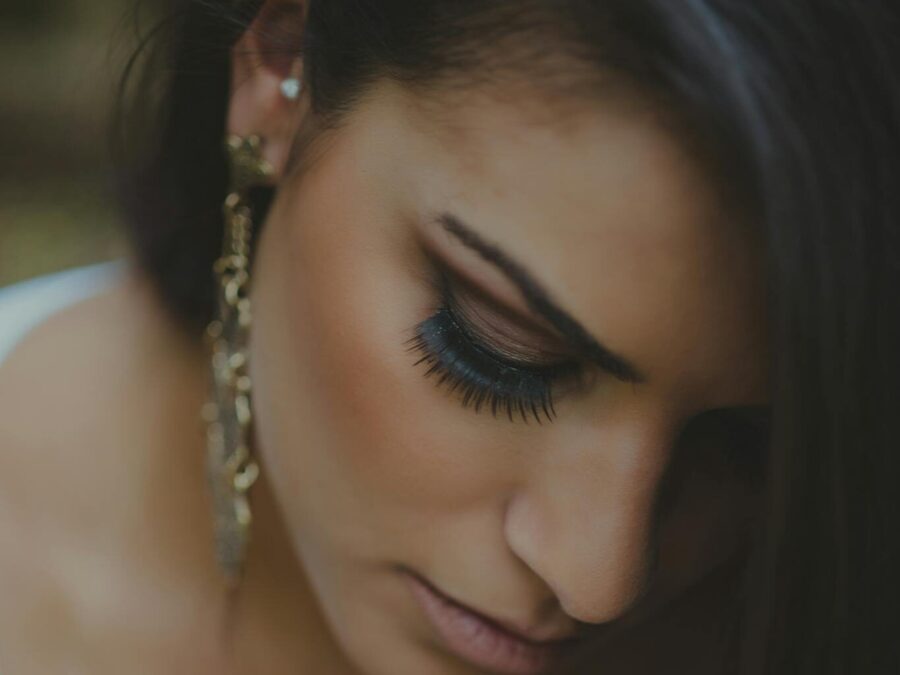 Intimate close-up of a woman with elegant jewelry and makeup, highlighting beauty.