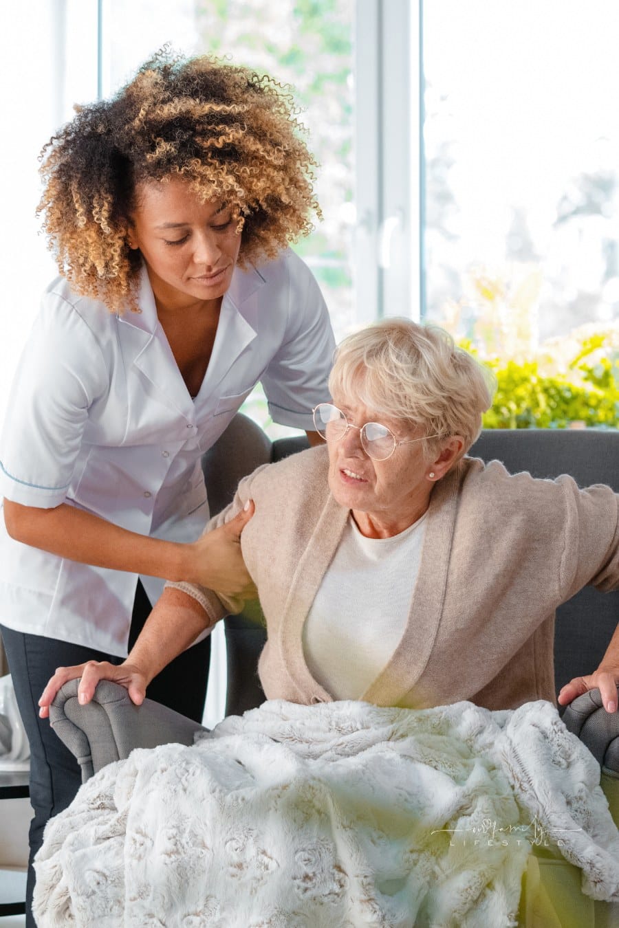Home nurse helping an elderly lady to stand up