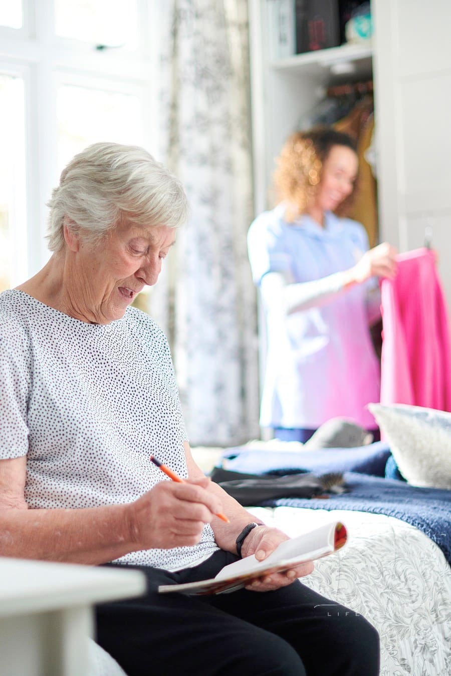 senior woman in assisted living home with female caregiver