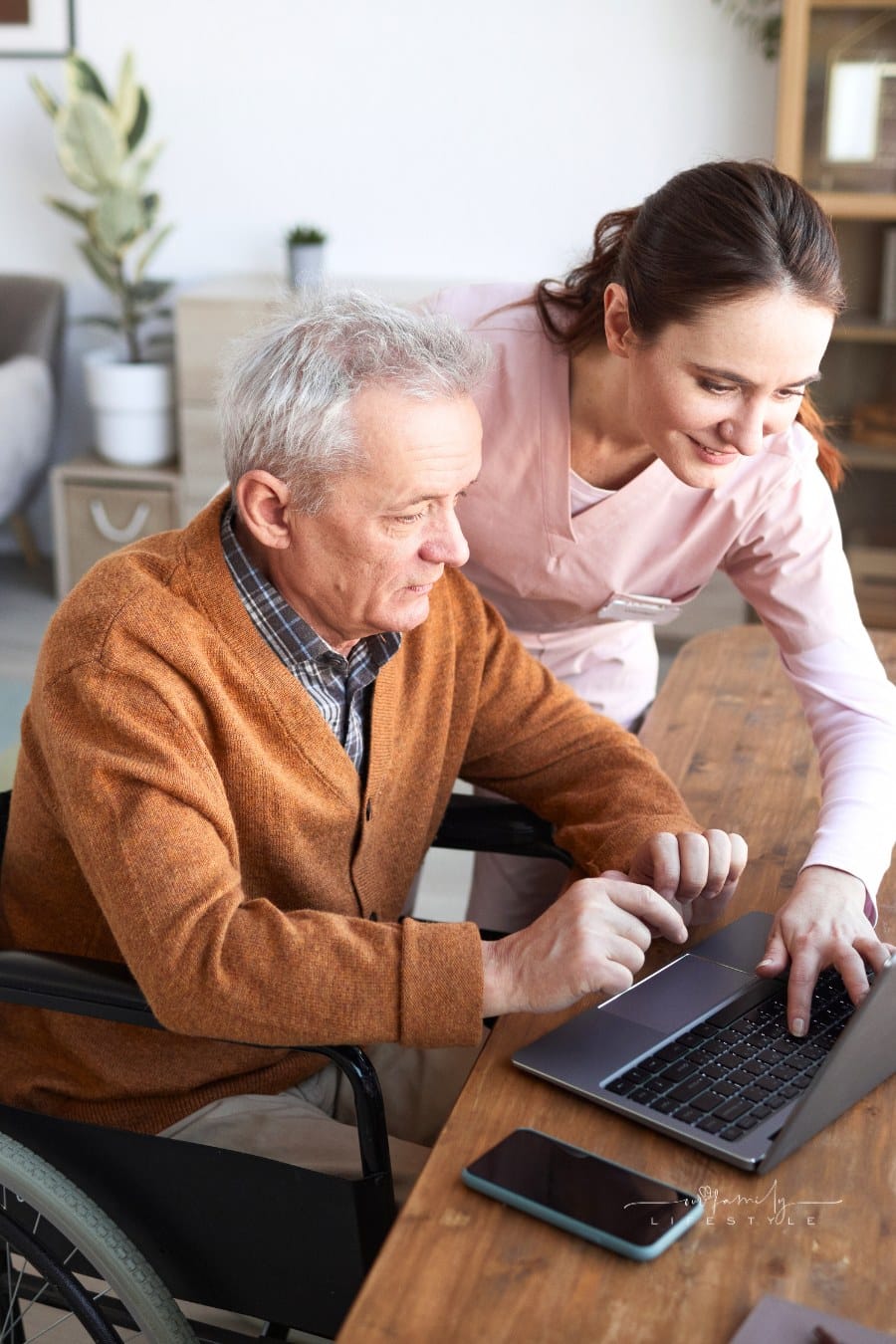 Caregiver Helping Senior Man Using Laptop