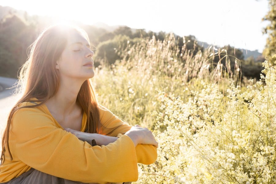 woman in nature enjoying the sunlight