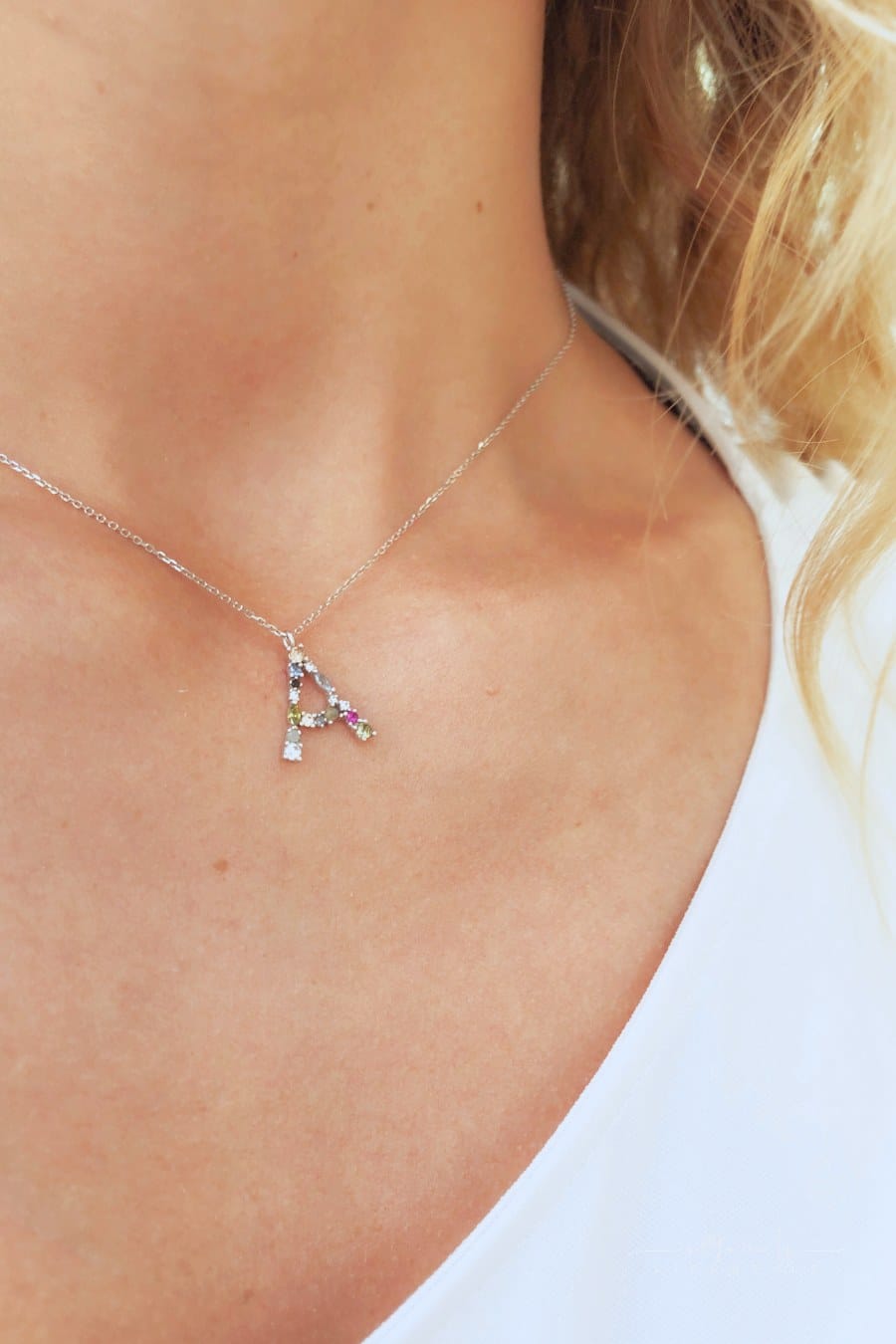 Silver initial A necklace on young woman’s neck