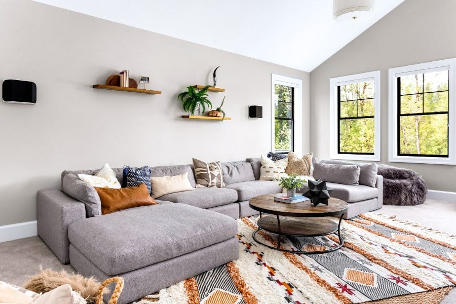 Beautiful living room interior with colorful area rug, large couch, and abundant natural light